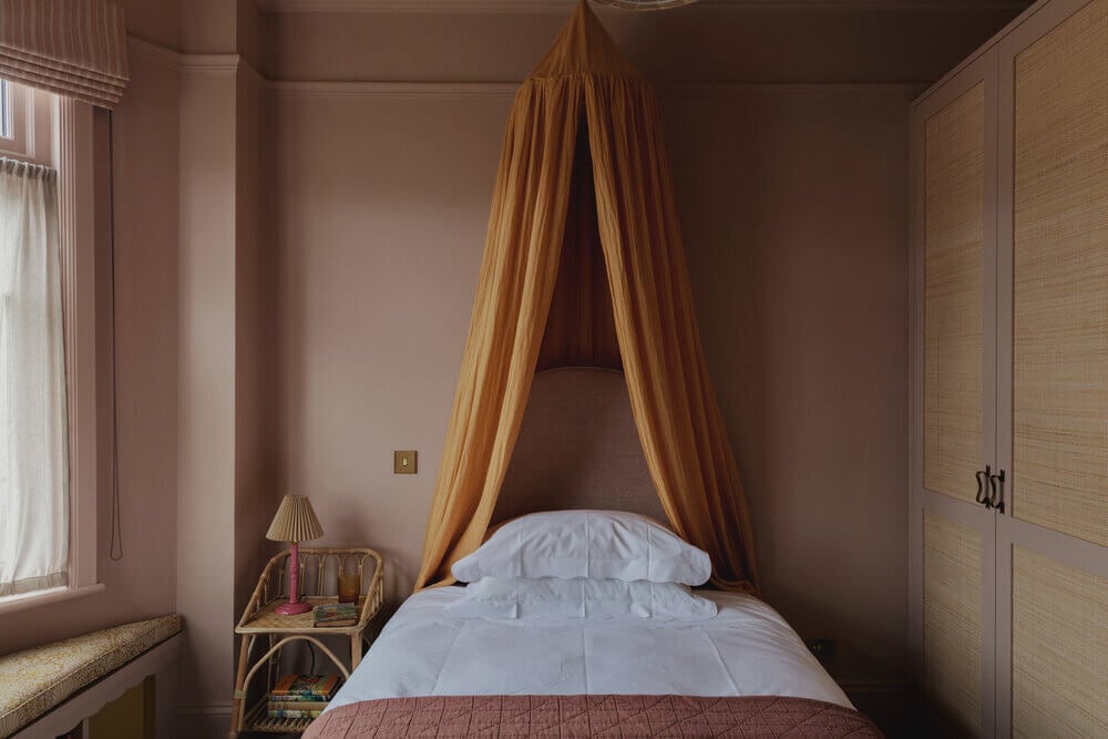 Warm Colors and Texture In A North London Family Home 14 pink-bedroom-yellow-canopy-cane-wardrobe-studio-duggan