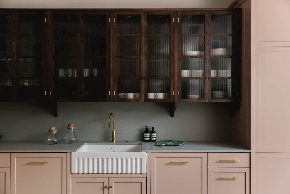 Warm Colors and Texture In A North London Family Home 4 pink-kitchen-ribbed-glass-cabinets-terrazzo-floor-london-studio-duggan-nordroom