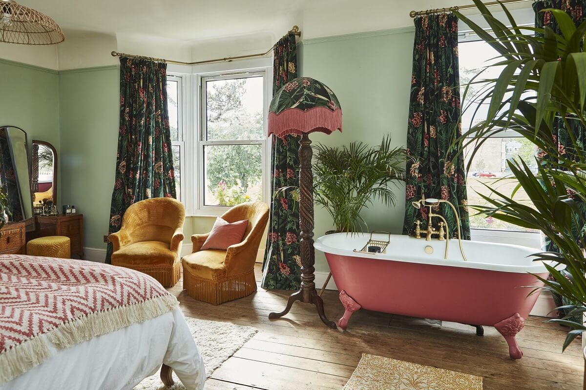 A Colorful 70s Inspired Home in London 18 master-bedroom-pink-clawfoot-bath-mustard-yellow-chairs-nordroom