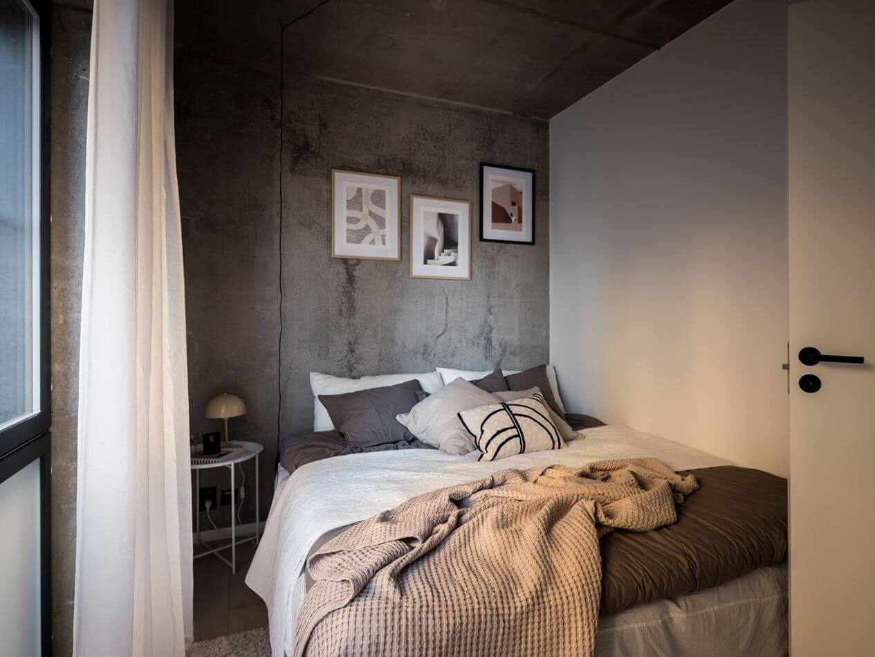 A Small Industrial Apartment with Pink Walls 10 small-bedroom-concrete-walls-built-in-closet-nordroom