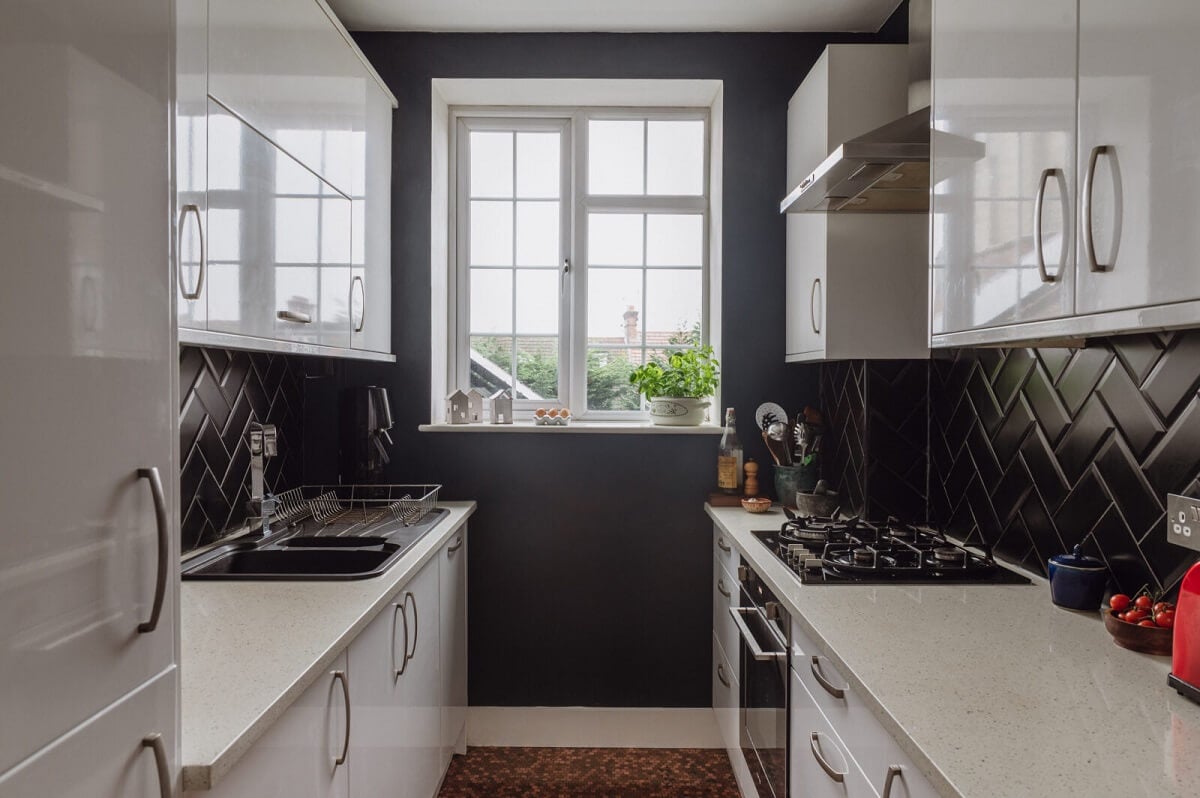 A Charming Two Bedroom Apartment in London 6 white-galley-kitchen-dark-blue-walls-black-tiles-nordroom