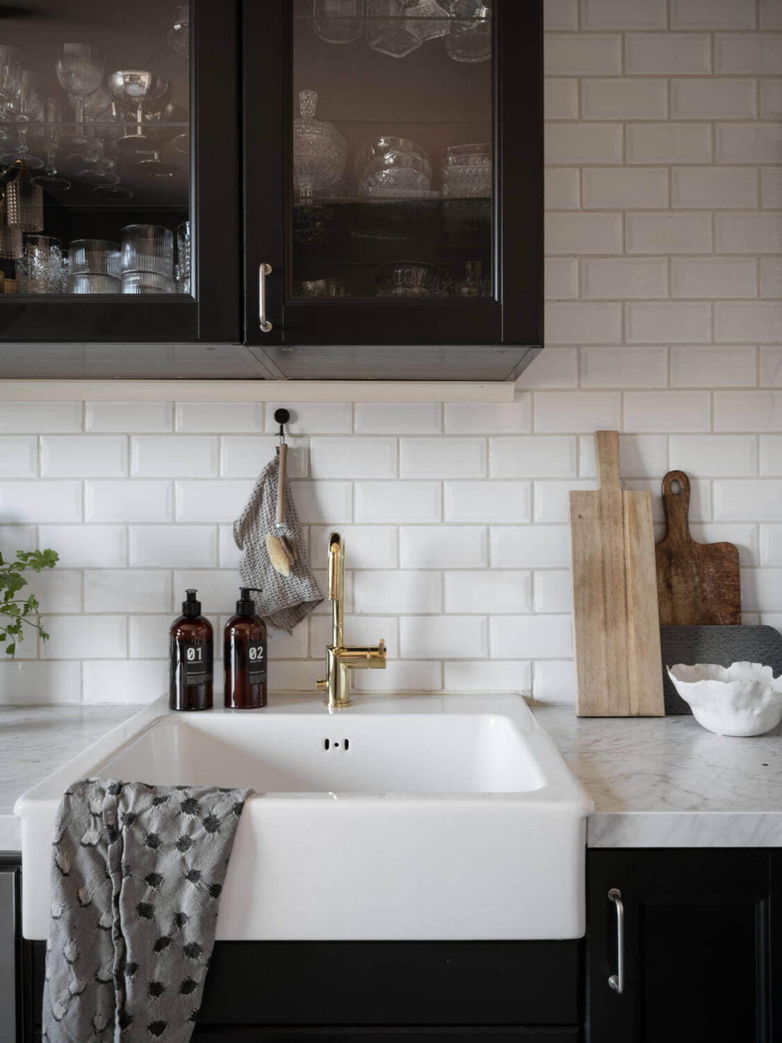 A Warm Neutral Colored Nordic Home 19 black-kitchen-cabinets-farmhouse-sink-nordroom