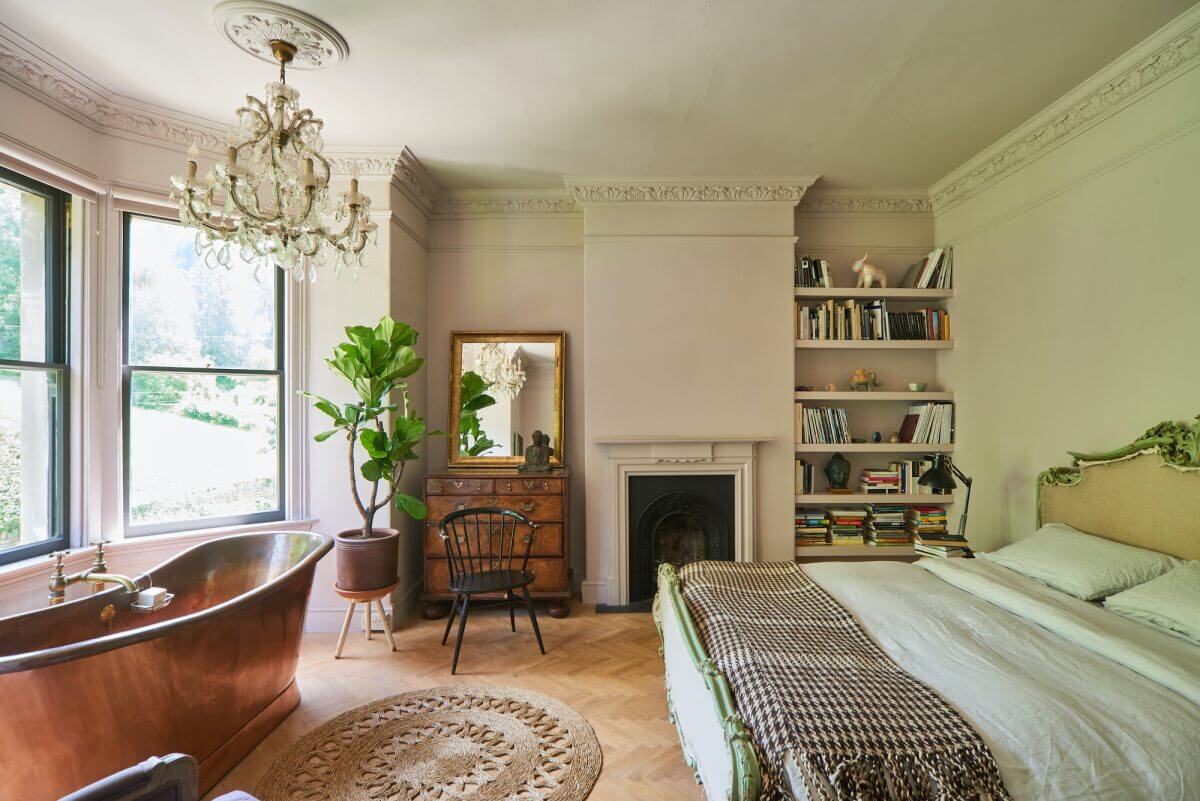 A Mixture of Styles in an English Home 11 master-bedroom-freestanding-copper-bath-fireplace-bookshelves-nordroom