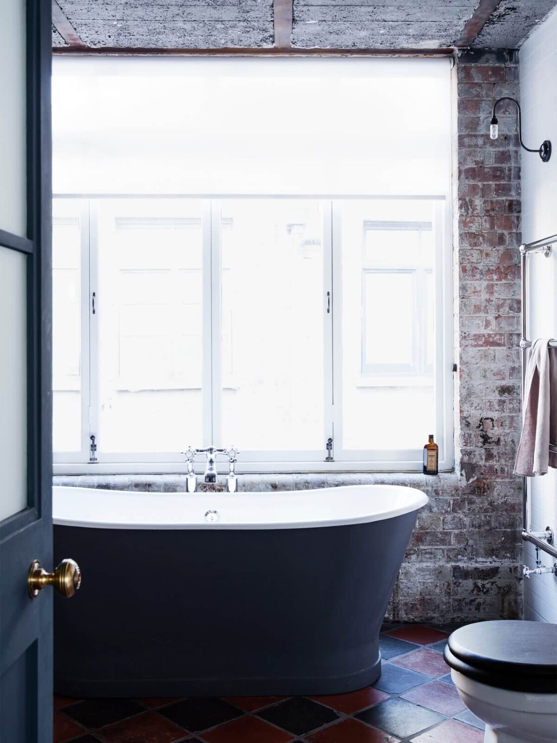 An Industrial Apartment by Mark Lewis Interior Design 15 bathroom-brick-wall-tiled-floor-freestanding-bath-nordroom