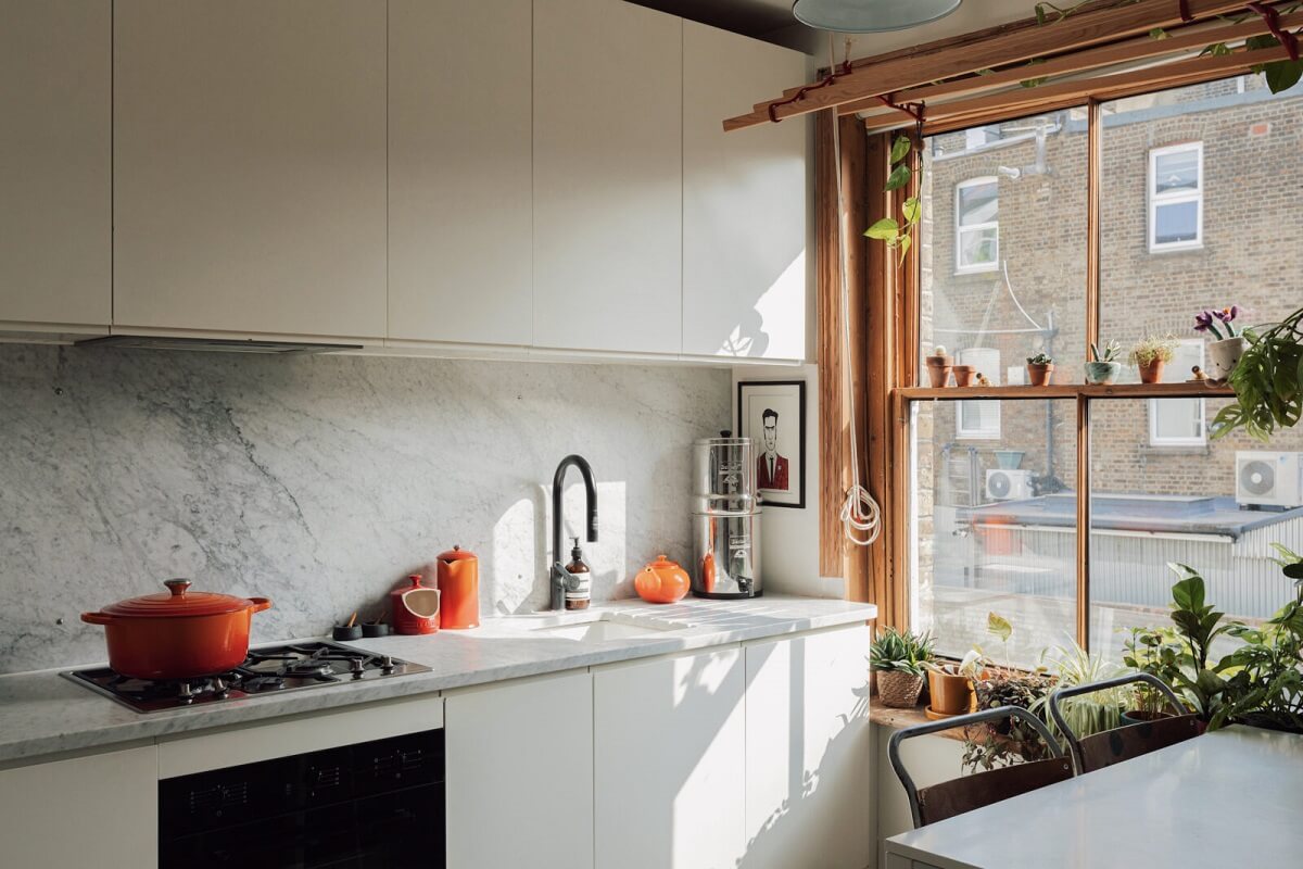 Colorful Rooms in an Edwardian Apartment in London 2 white-kitchen-cabinet-carrara-marble-worktop-stripped-wooden-window-frames-nordroom