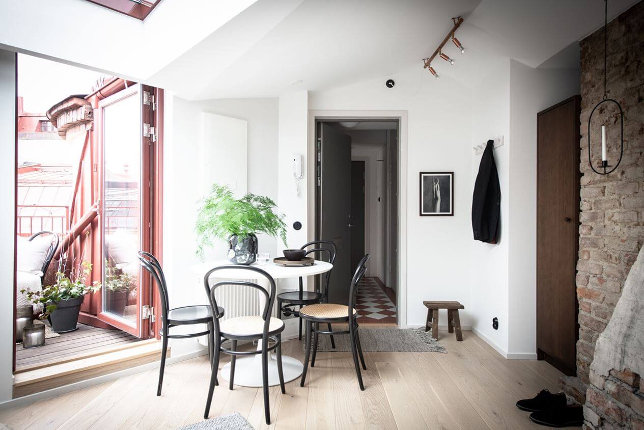 A Light Nordic Attic Loft with Raw Walls and Skylights 11 attic-apartment-dining-space-balcony-exposed-brick-skylight-nordroom