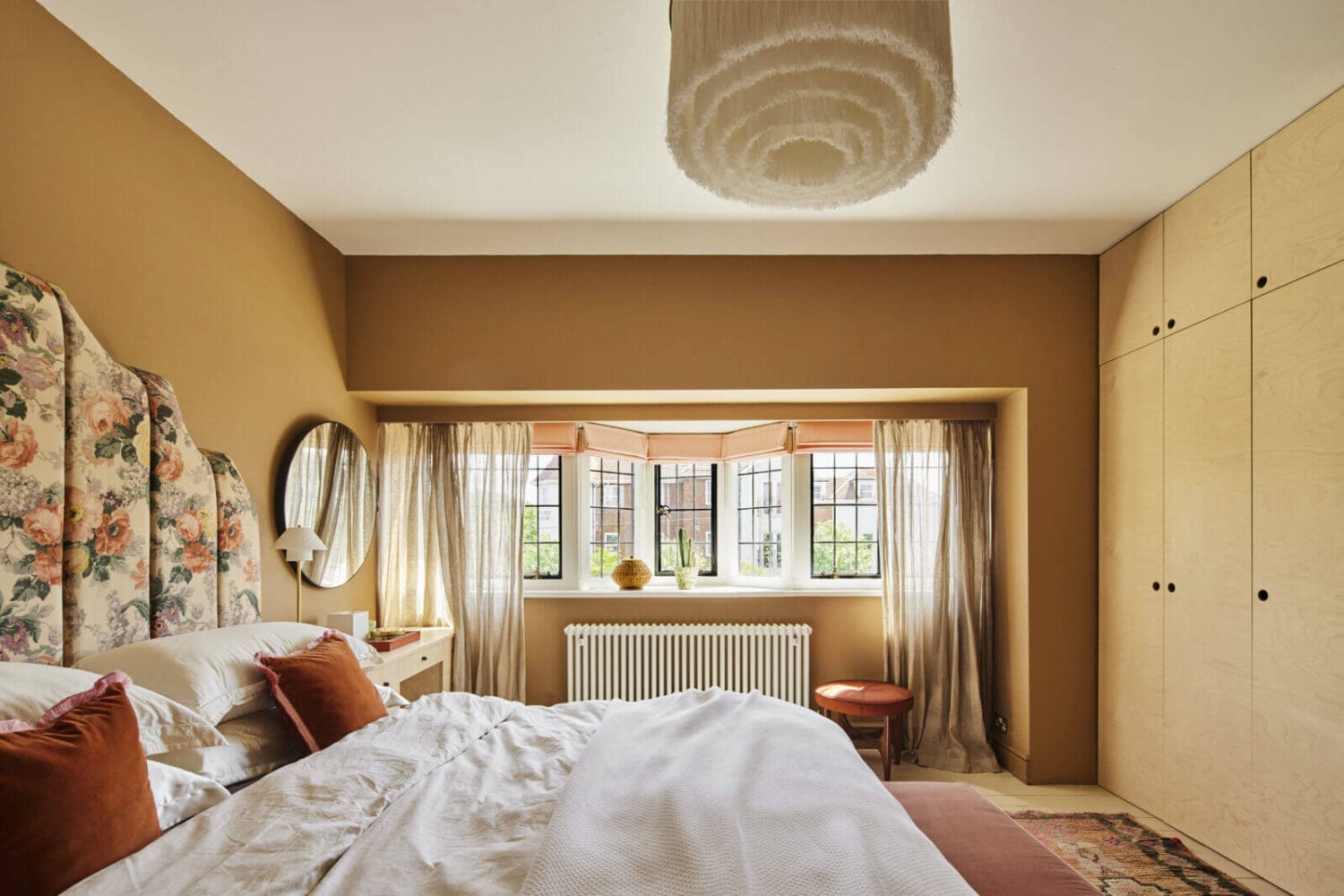 An Arts and Crafts House with Colorful Rooms 18 bedroom-floral-headboard-warm-wall-color-built-in-wardrobes-nordroom