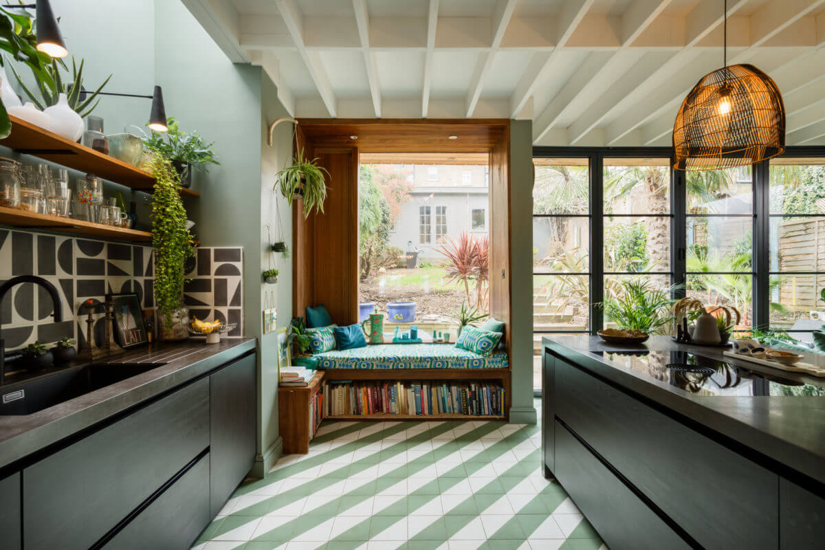 A Colorful Maximalist Home in London 7 black-kitchen-cabinets-green-walls-window-seat-green-white-diagonal-floor-tiles-nordroom