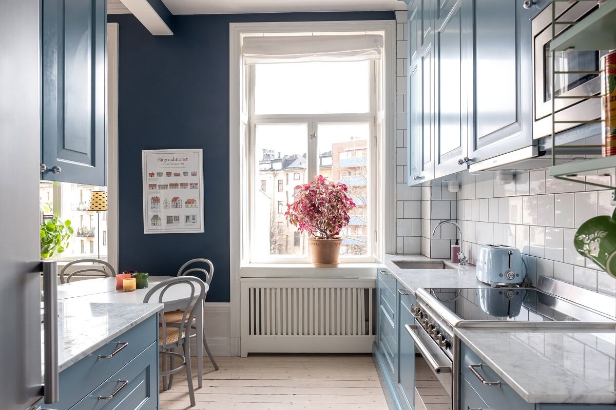 A Nordic Home with Blue Sitting Room and Kitchen 14 blue-galley-kitchen