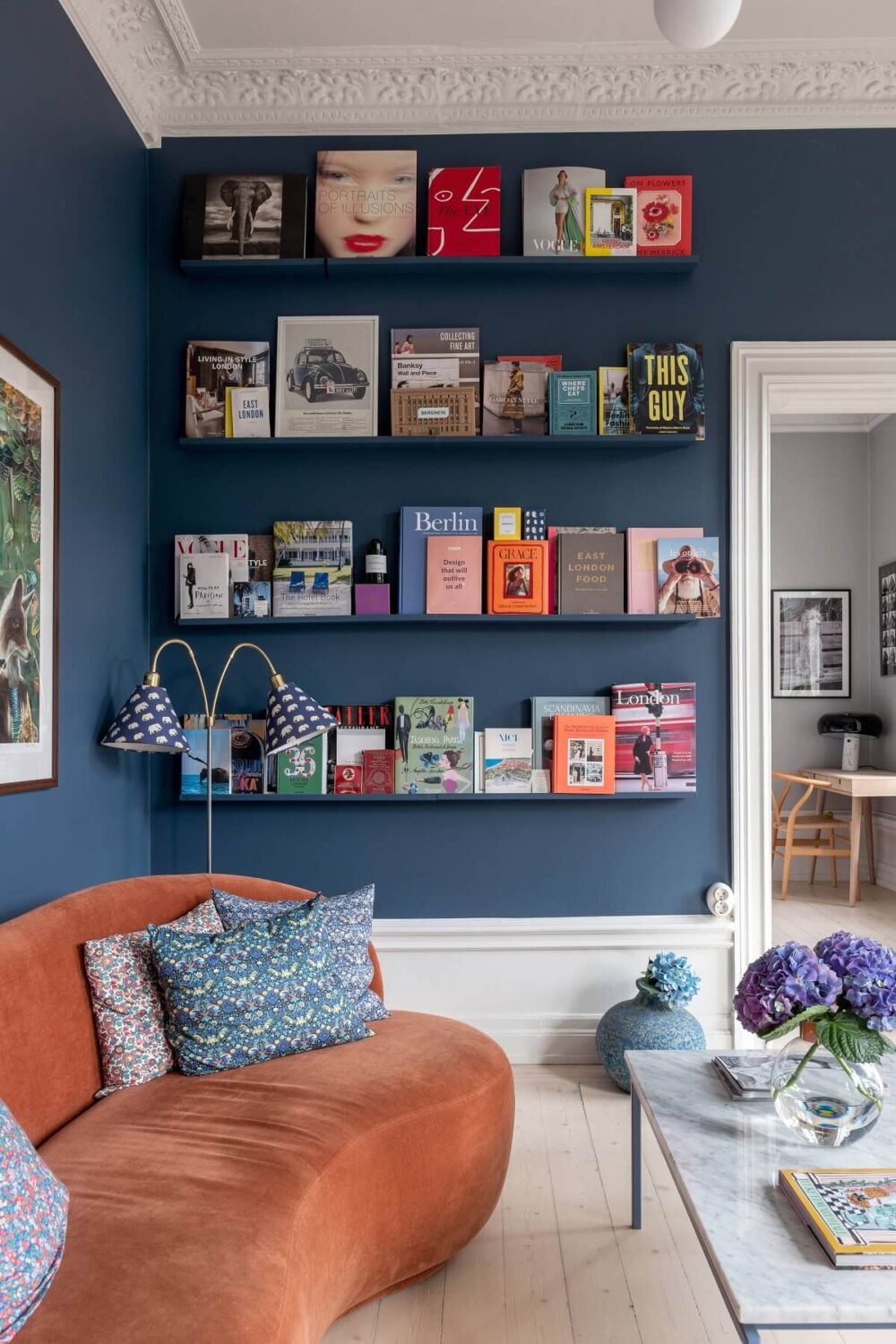 A Nordic Home with Blue Sitting Room and Kitchen 4 book-ledges-rust-red-curved-sofa-nordroom