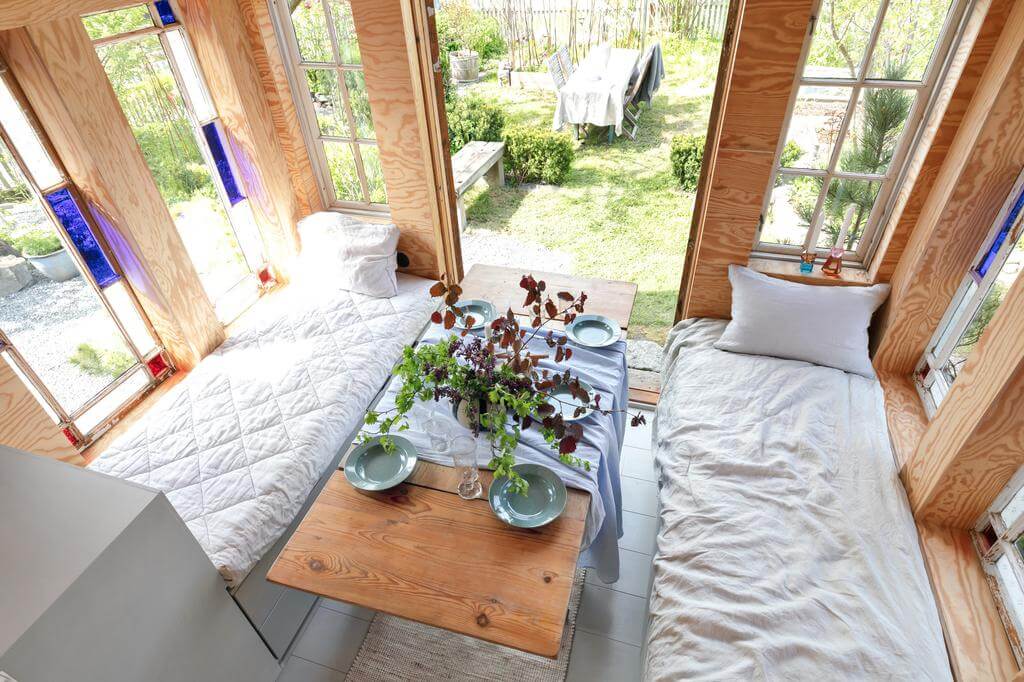 A Red Wooden Cottage on a Swedish Allotment 9 daybed dining area swedish cottage nordroom A Red Wooden Cottage on a Swedish Allotment