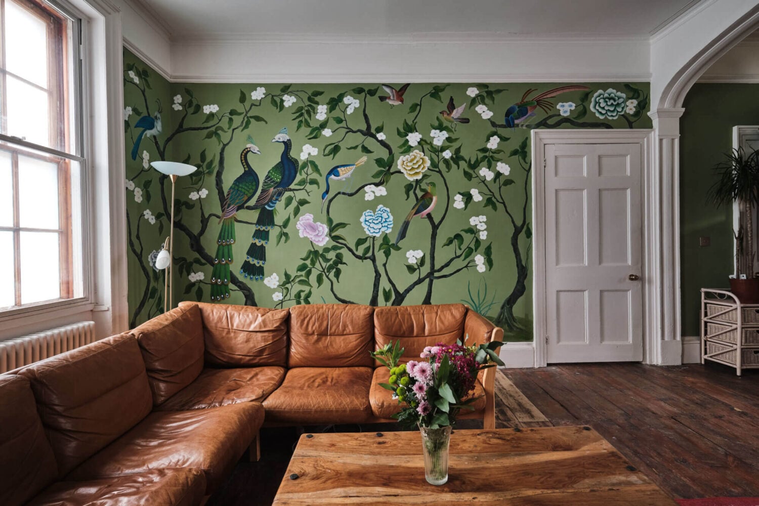 A Colorful Eclectic Home in England 13 green-botanical-mural-sitting-room-leather-sofa-nordroom