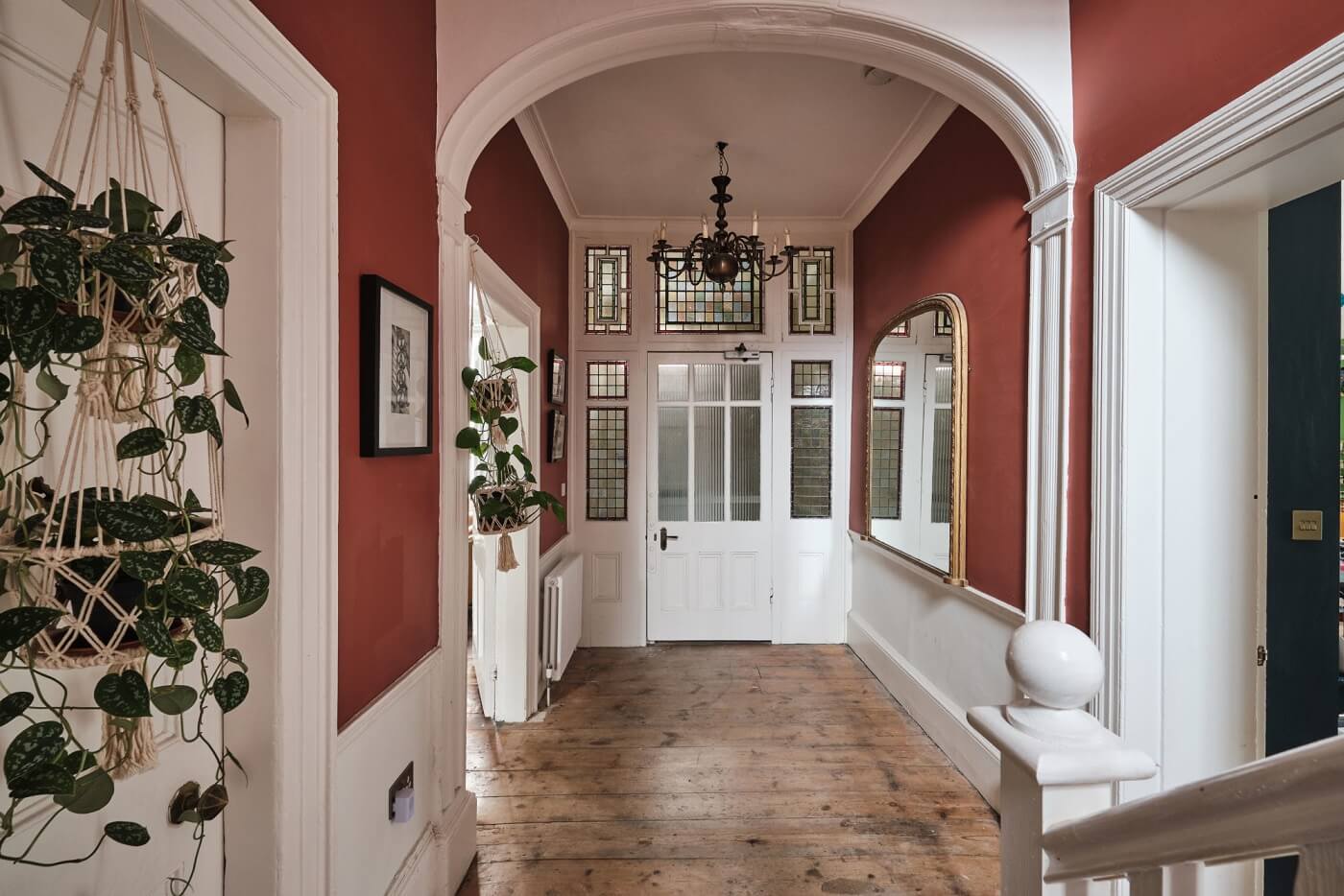 A Colorful Eclectic Home in England 21 hallway-original-details-red-walls-arched-doorway-wooden-floor-nordroom