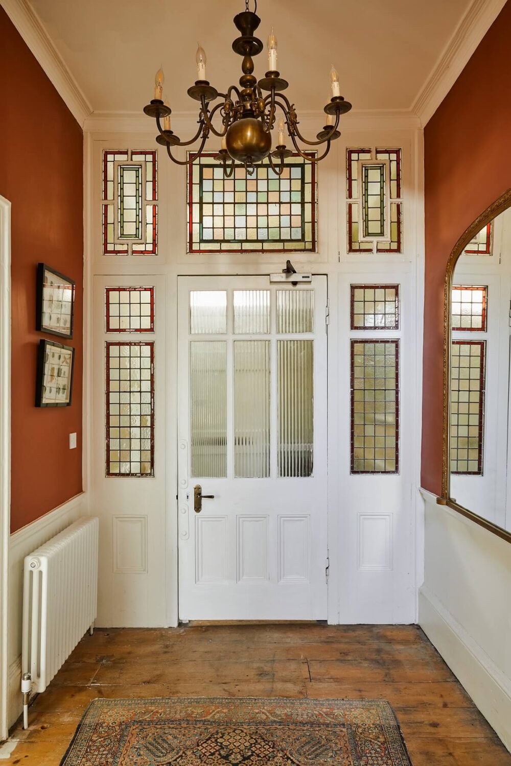 A Colorful Eclectic Home in England 23 hallway-wooden-floor-red-walls-original-doors-nordroom