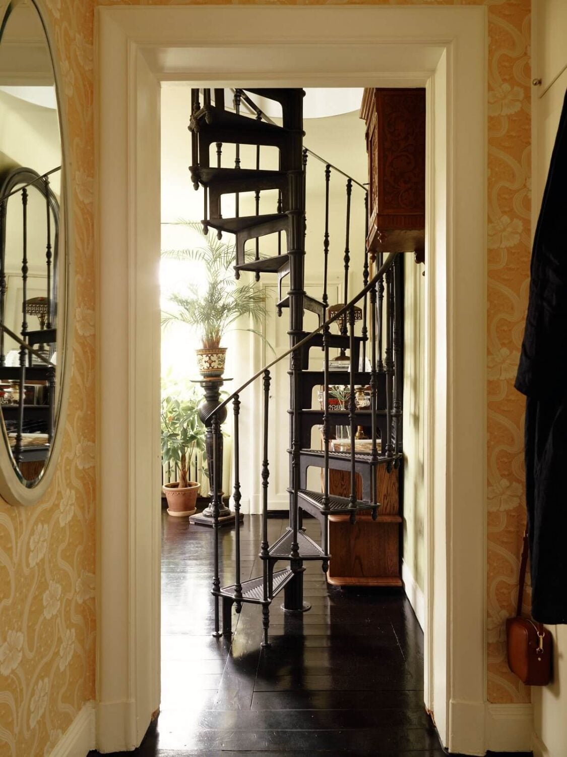 A Cozy Vintage Bohemian Maisonette in Sweden 11 hallway-yellow-wallpaper-black-floorboards-spiral-stairs-nordroom