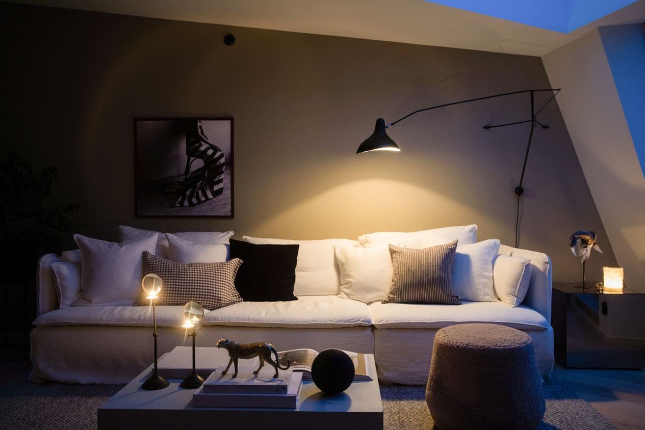 A Light Nordic Attic Loft with Raw Walls and Skylights 5 large-white-scandinavian-sofa-wall-lamp-attic-apartment-nordroom