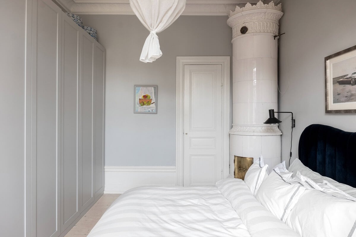 A Nordic Home with Blue Sitting Room and Kitchen 20 light-gray-bedroom-green-velvet-headboard-fireplace-built-in-wardrobes-nordroom