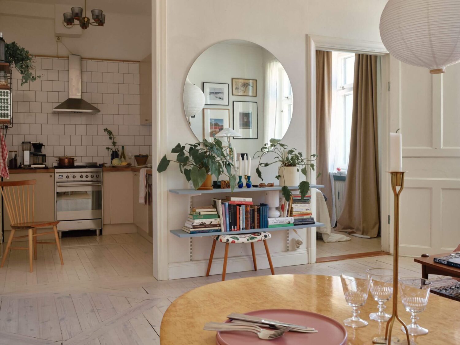 A Charming Apartment with Muted Blue Bedroom 9 open-plan-living-room-kitchen-round-mirror-blue-shelves-nordroom
