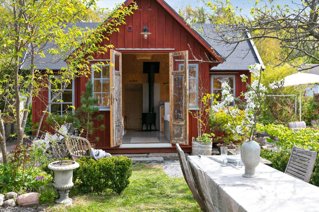 A Red Wooden Cottage on a Swedish Allotment 10 red wooden cottage double doors garden nordroom A Red Wooden Cottage on a Swedish Allotment
