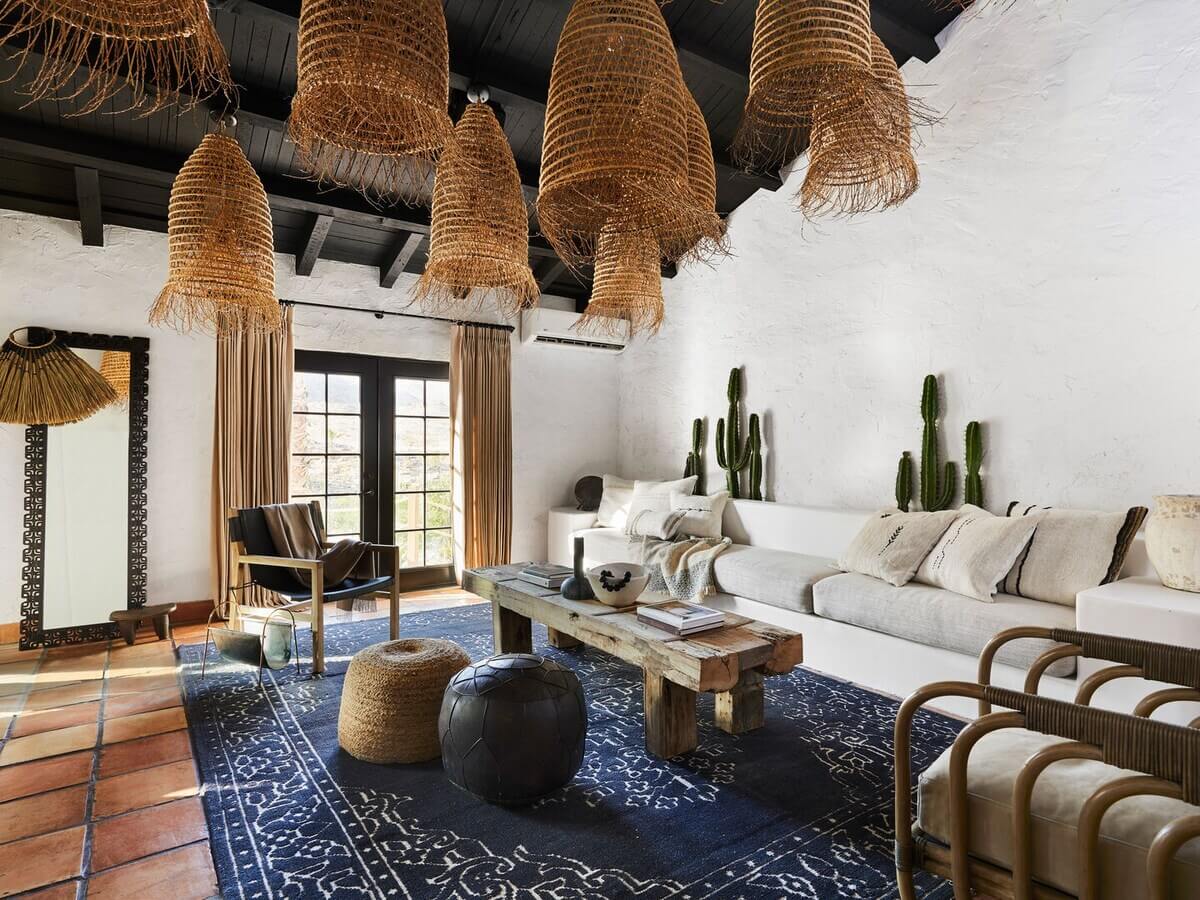 Queer Eye's Bobby Berk Designed An Airbnb Villa in California 1 sitting-room-stone-floor-blue-rug-black-painted-wooden-ceiling-nordroom