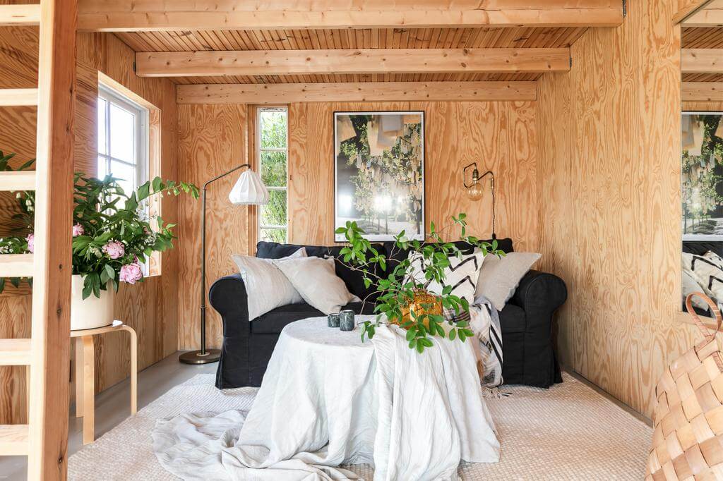 A Red Wooden Cottage on a Swedish Allotment 3 wooden cottage holiday home black ikea sofa nordroom A Red Wooden Cottage on a Swedish Allotment
