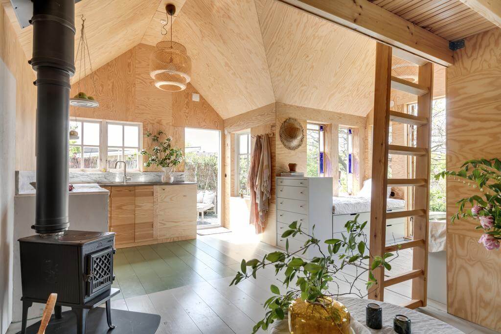 A Colored Sixth Wall May Be The Biggest Paint Trend in 2026 9 wooden cottage loft cast iron stove painted wooden floor nordroom A Colored Sixth Wall May Be The Biggest Paint Trend in 2026