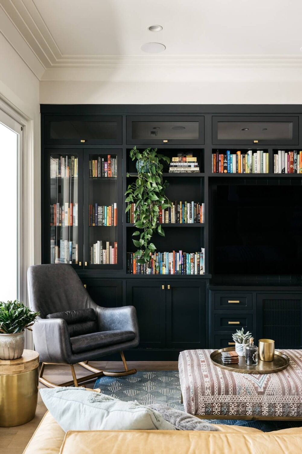 The Los Angeles Home of Emmy Raver-Lampman and Daveed Diggs 8 black-built-in-bookshelves-television-armchair-daveed-diggs-emmy-raver-lampman