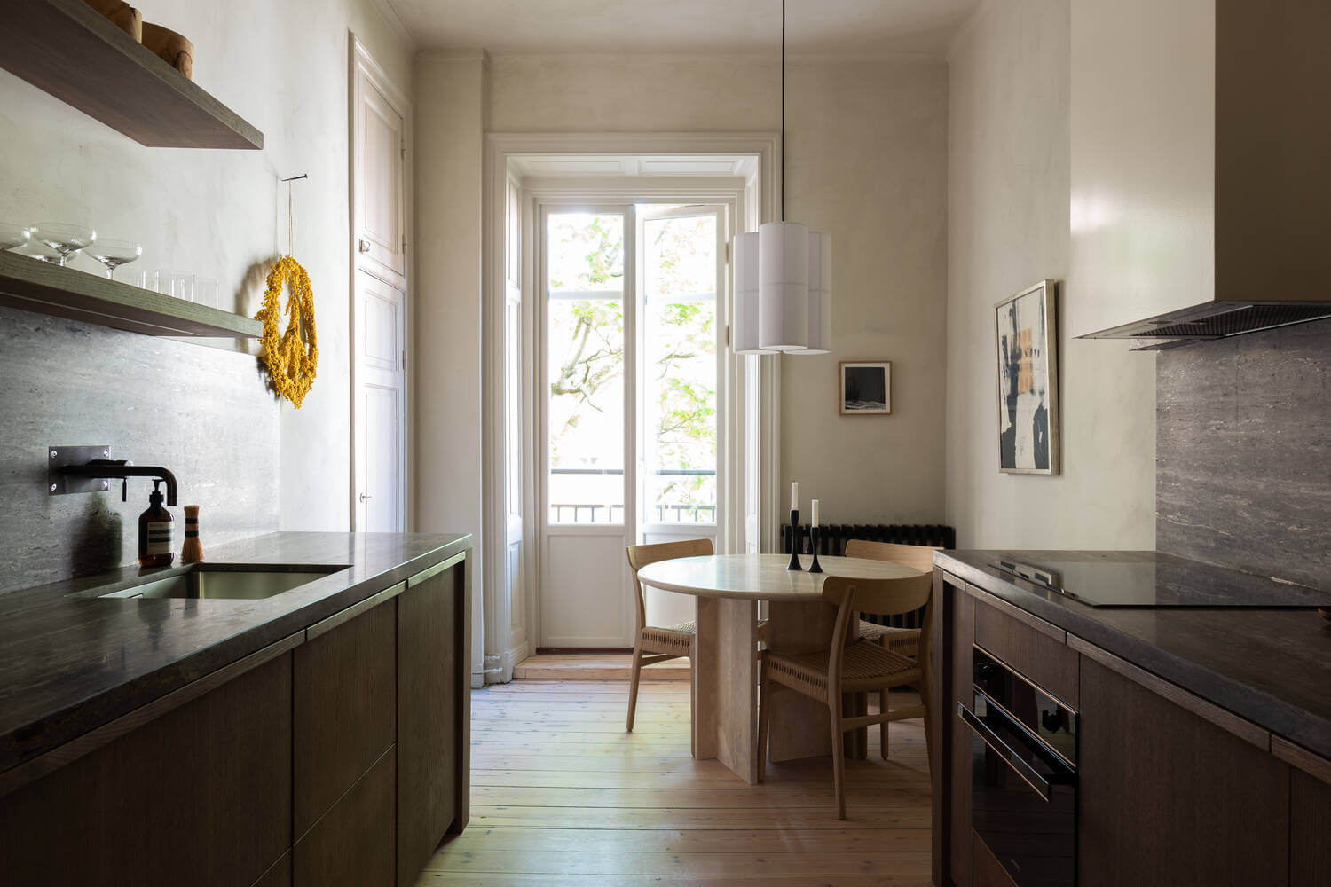 Japandi Interior Design in a Small Nordic Home 10 dark-wooden-galley-kitchen-round-dining-table-nordroom