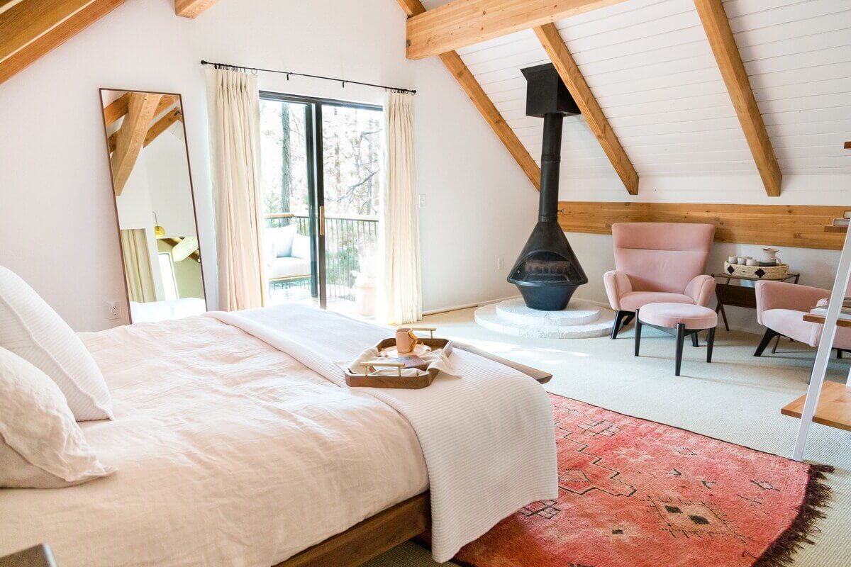 The Kitchy Cabin: A Lovely Airbnb Home in California 13 master-bedroom-sloped-ceilings-seating-pink-armchair-pink-rug-nordroom