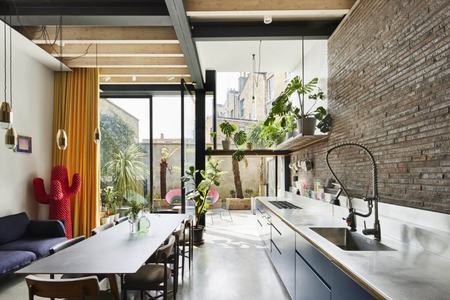 The Makers House: A Modern Achitectural Home in London 2 open-plan-kitchen-blue-cabinets-brick-wall-glass-wall-high-ceiling-themakers-house-nordroom