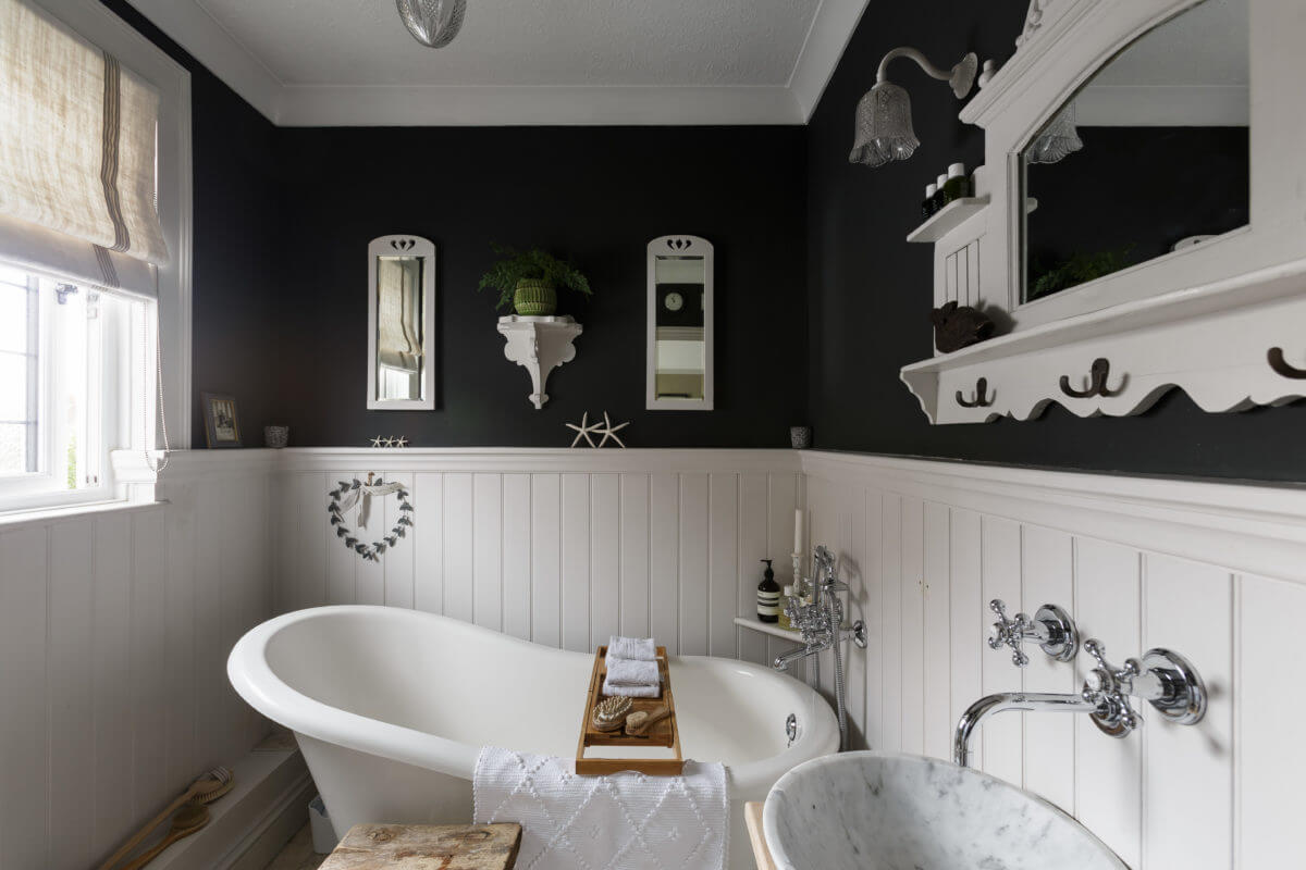 A Cozy Cottage-Style Country House with a Lovely Garden 20 bathroom-freestanding-bath-white-tiles-black-walls-nordroom