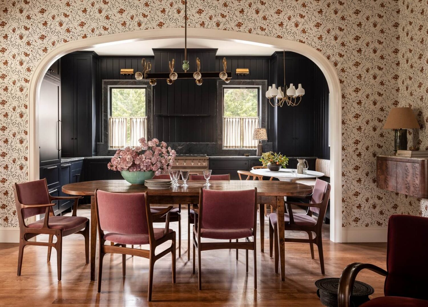 Pink Tones and Black in a Stunning Fox Island Home 3 dining-room-arched-doorway-pink-velvet-chairs-floral-wallpaper-nordroom