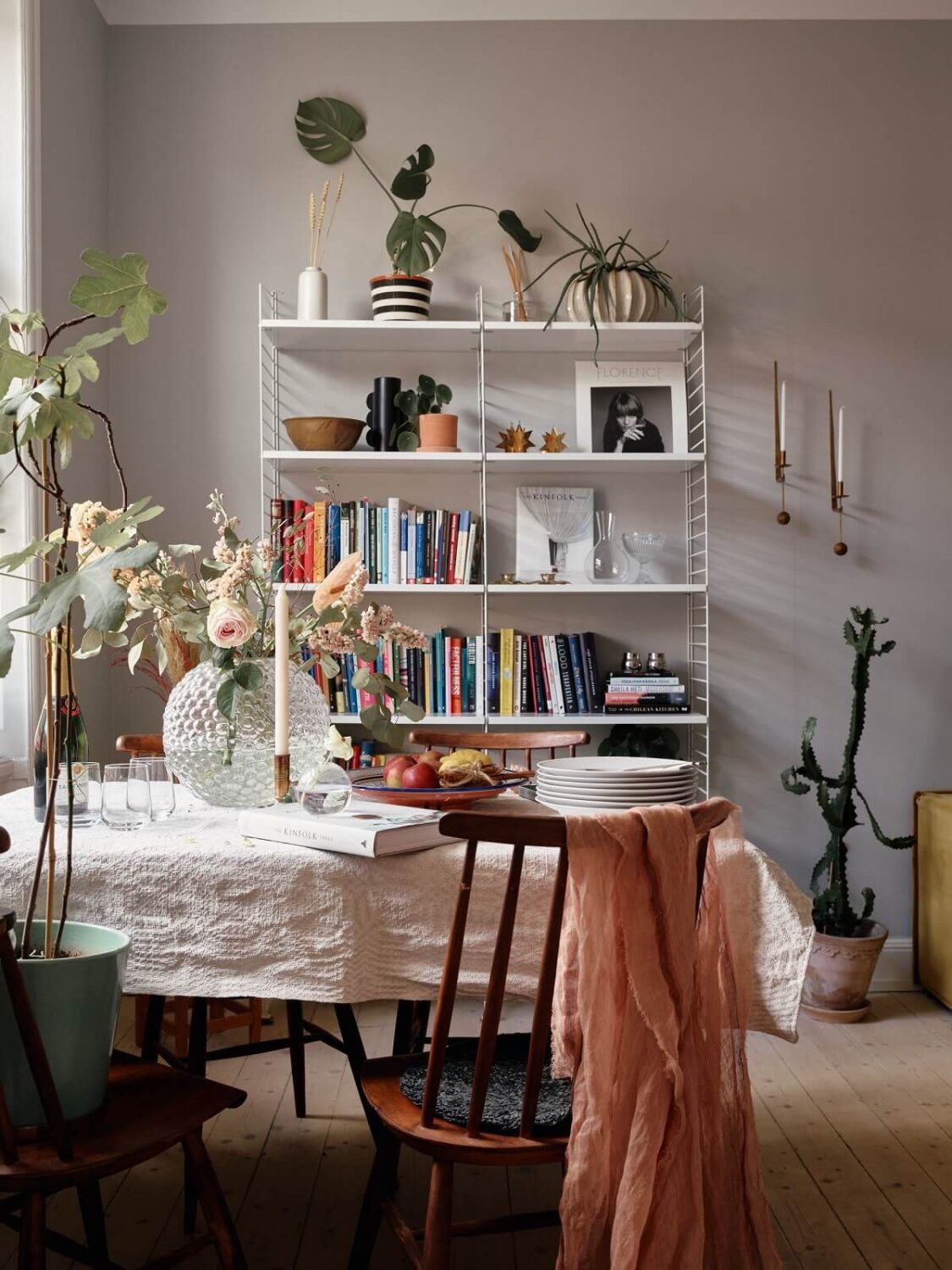 A Small Swedish Apartment with Ochre Yellow Sofa 8 dining-table-bookshelves-gray-walls-nordroom
