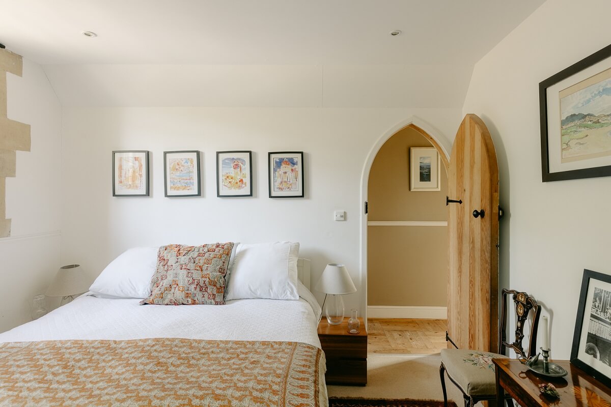 A Warm Church Conversion in England 18 white-bedroom-arched-door-church-conversion-nordroom
