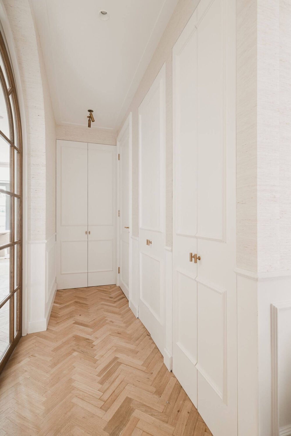 Color and Wallpaper in a Stylish Amsterdam Home 11 white-hallway-wooden-floor-built-in-cabinets-nordroom
