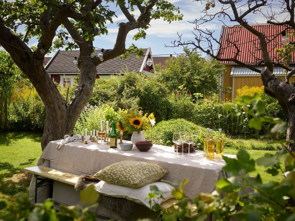 A Cozy Renovated Cottage on a Swedish Allotment 18 cozy-garden-dining-area-trees-nordroom