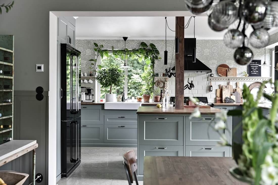 A Swedish 1930s Villa Decorated in Gray and Green Tones 7 cozy-kitchen-plants-island-green-cabinets-nordroom