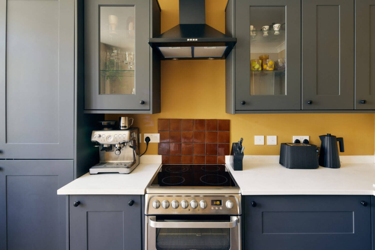 A One-Bedroom Apartment with Colorful Rooms 5 gray-kitchen-cabinets-yellow-walls-nordroom