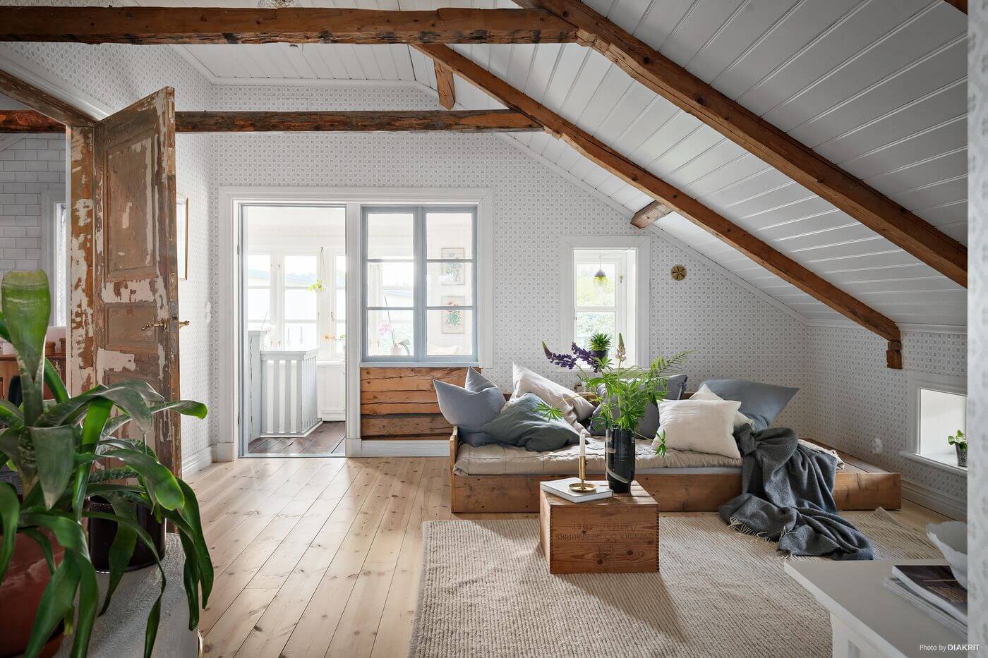 A Charming Swedish Villa Filled with Wallpaper 14 sitting-room-sloped-ceiling-wooden-beams-nordroom