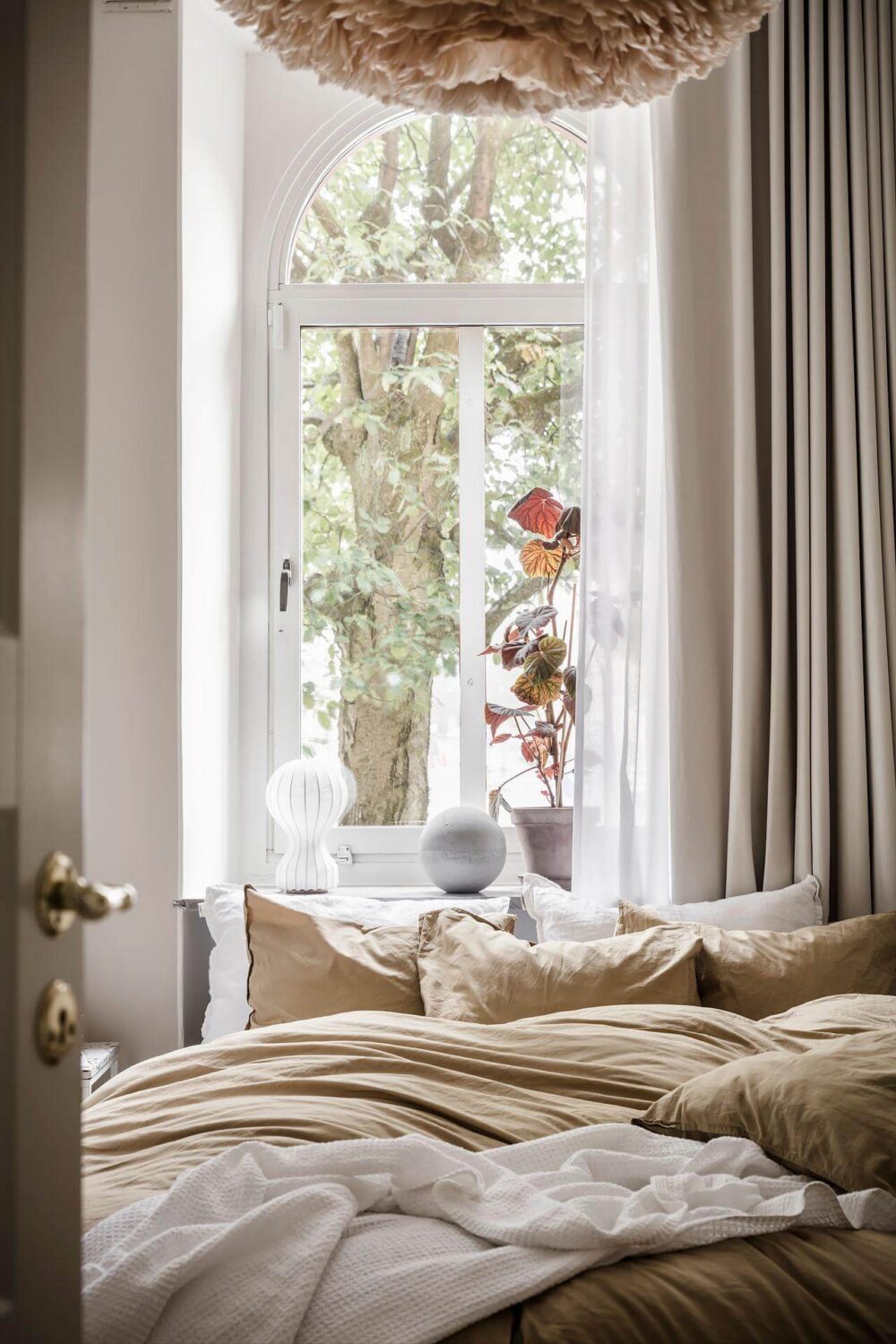 A Tiny and Stylish Nordic Apartment 16 small-narrow-bedroom-arched-window-nordroom