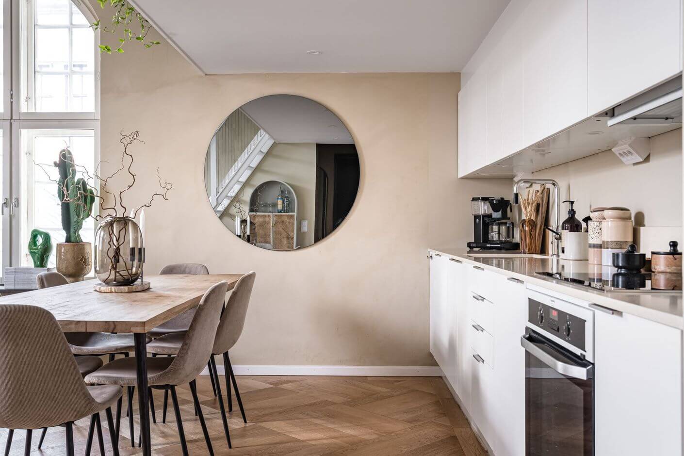 A Historic Factory Transformed Into A Stylish Home 14 white-kitchen-cabinet-round-mirror-dining-table-nordroom