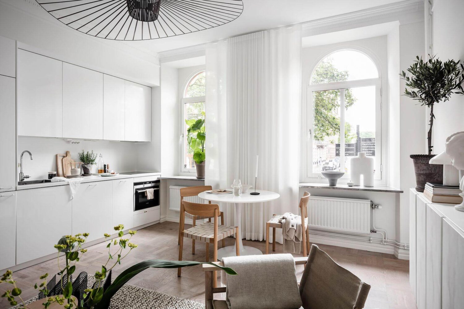 A Tiny and Stylish Nordic Apartment 12 white-kitchen-cabinets-round-dining-table-nordroom