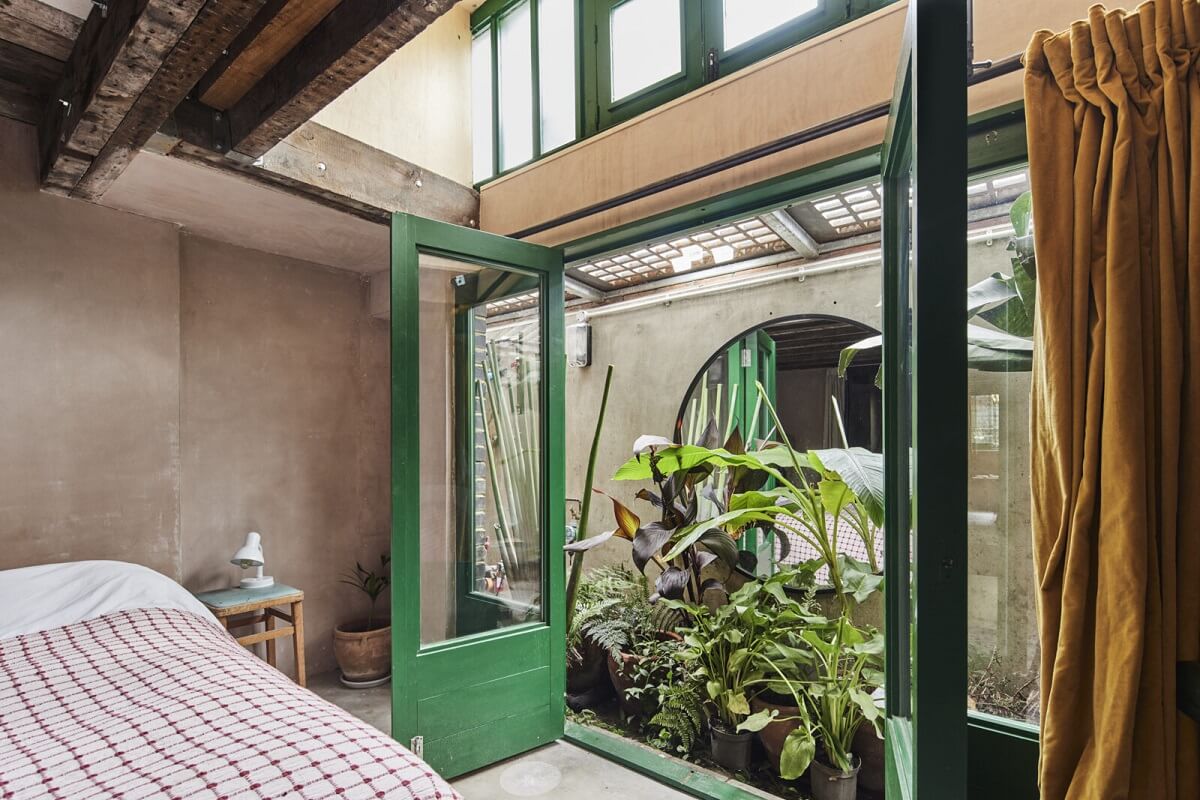 A Unique Home in a Former Furniture Workshop 13 bedroom-courtyard-garden-ochre-curtains-nordroom