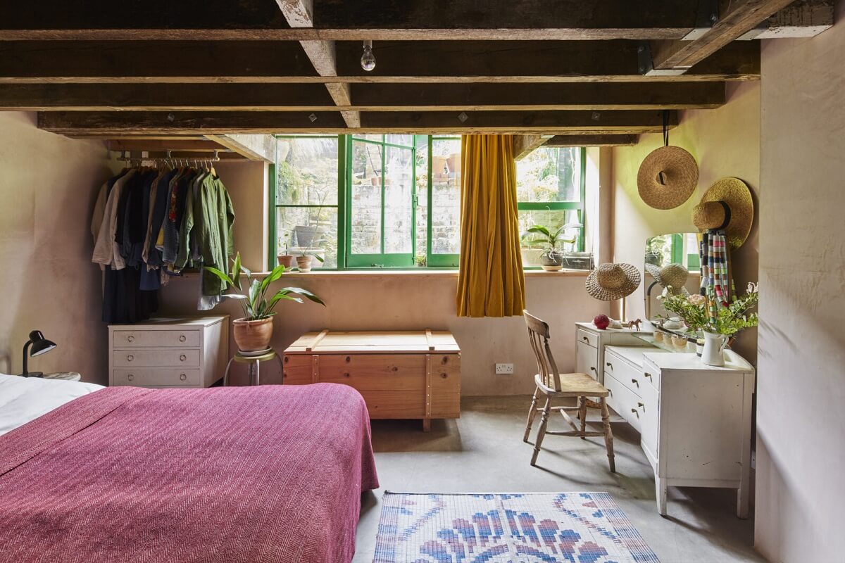 A Unique Home in a Former Furniture Workshop 17 bedroom-pink-bedspread-exposed-wooden-ceiling-vanity-table-nordroom