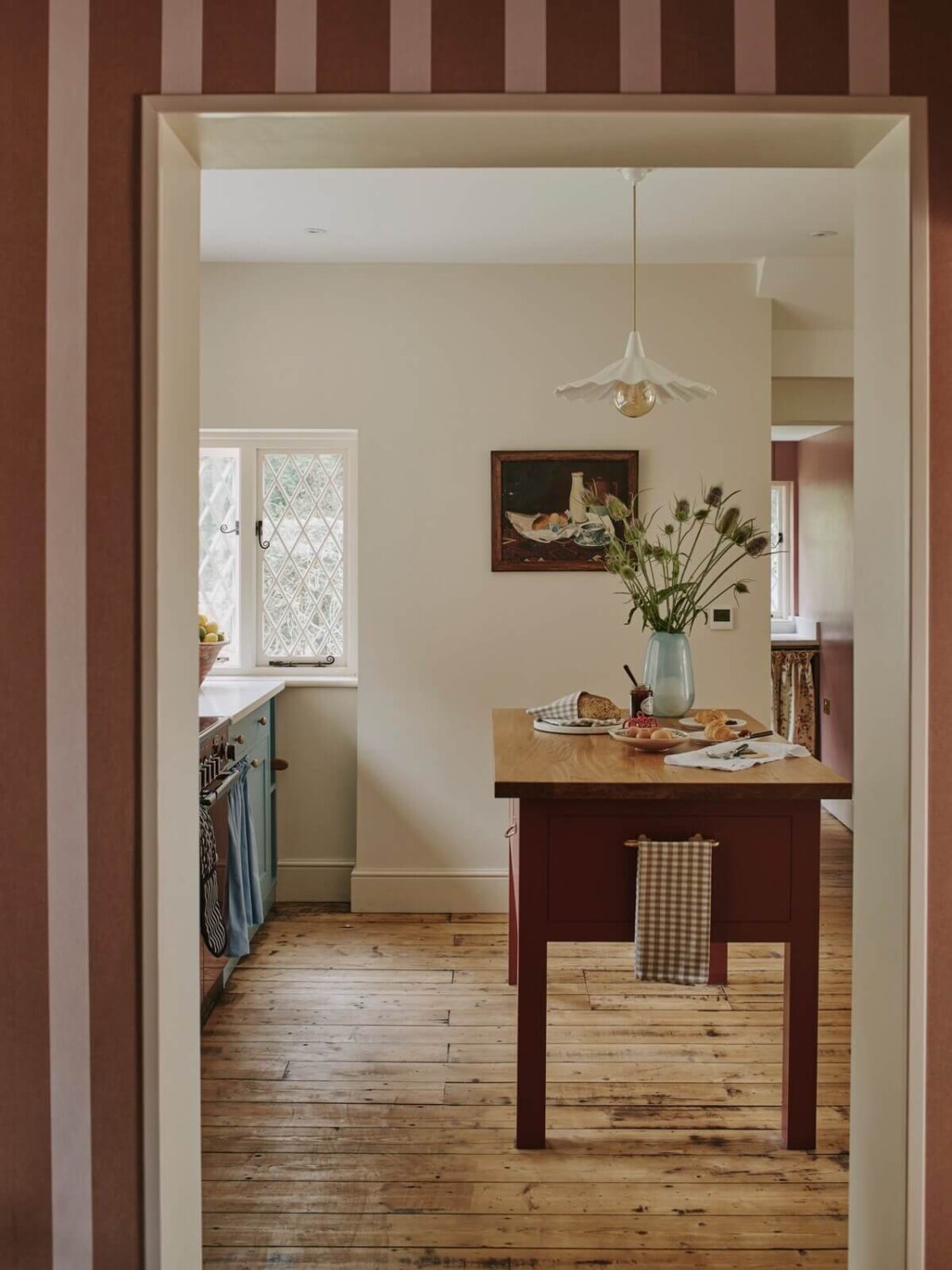 A Magical Pink Cottage in the English Countryside 3 cottage-kitchen-blue-cabinets-striped-wallpaper-nordroom