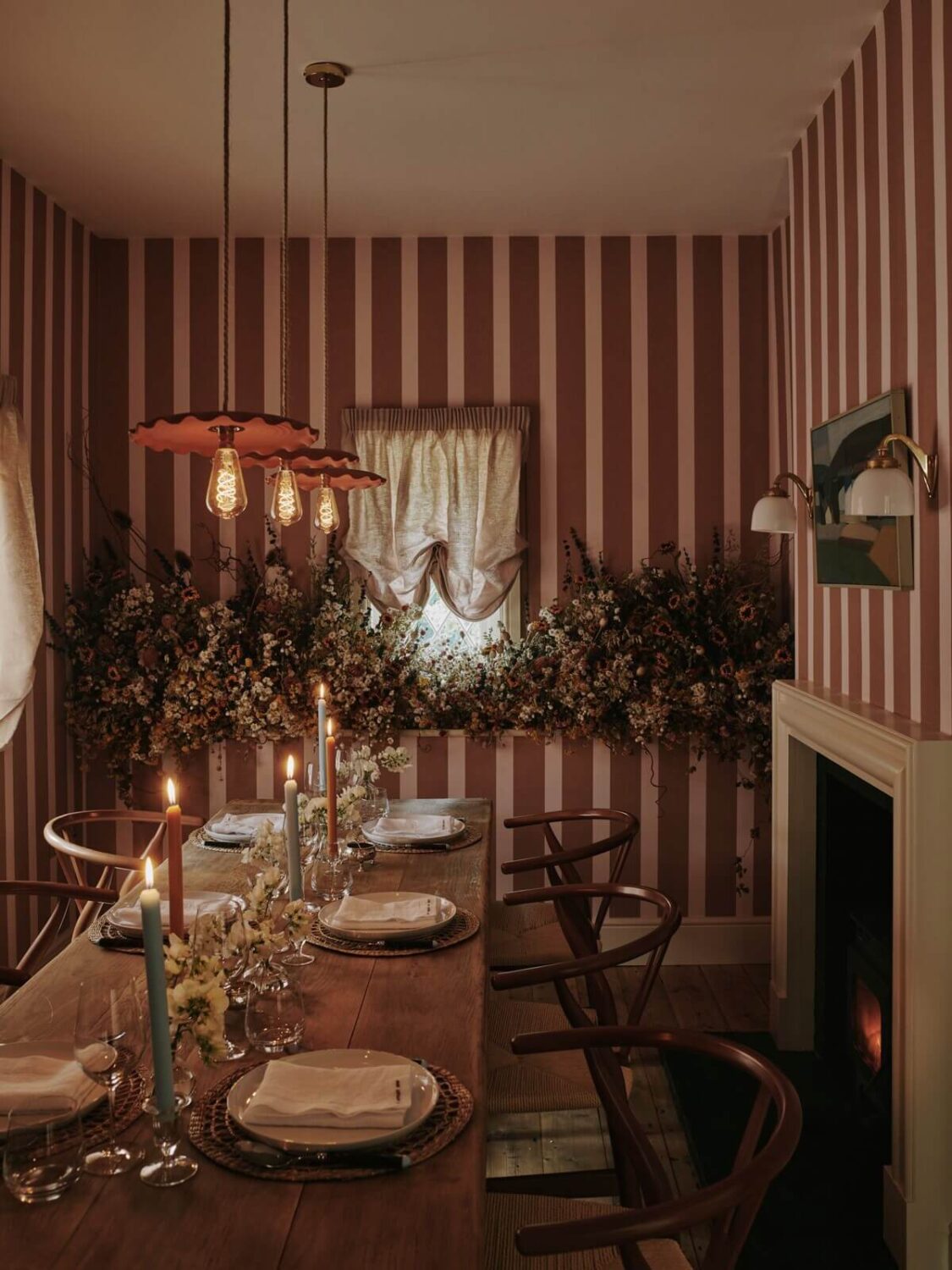 Interior Design Trends for 2024: Comfort, Nature, and Warmth 29 cozy-dining-room-striped-wallpaper-fireplace-rustic-table-wishbone-chairs-nordroom