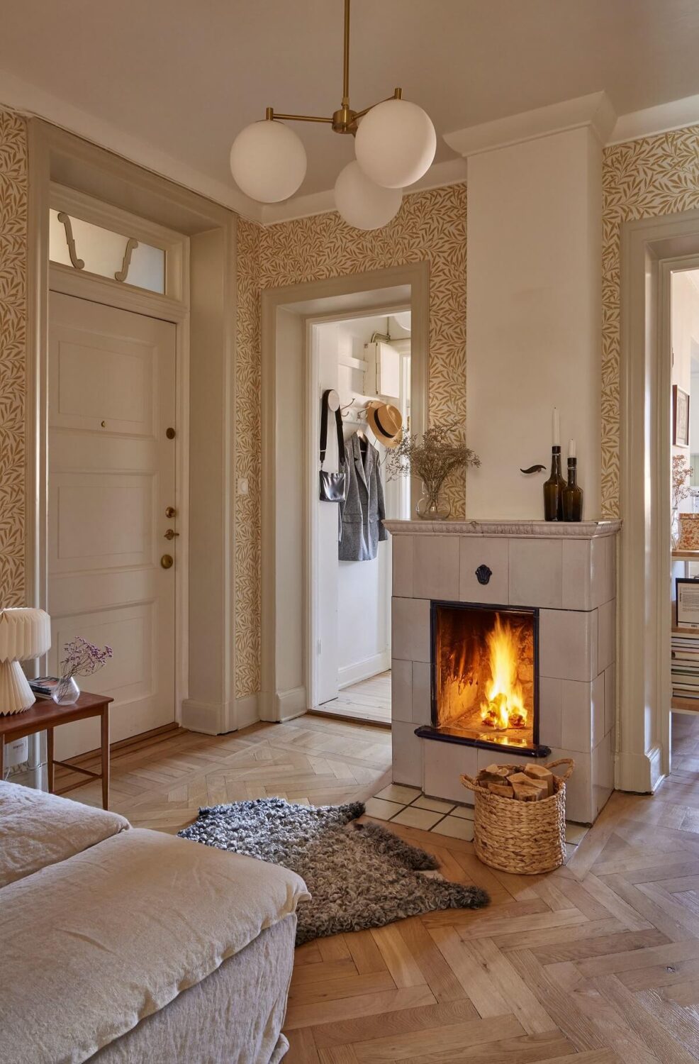 A Small Nordic Home Decorated in Warm Light Colors 8 hallway-tiled-fireplace-william-morris-willow-wallpaper-wooden-floor-nordroom