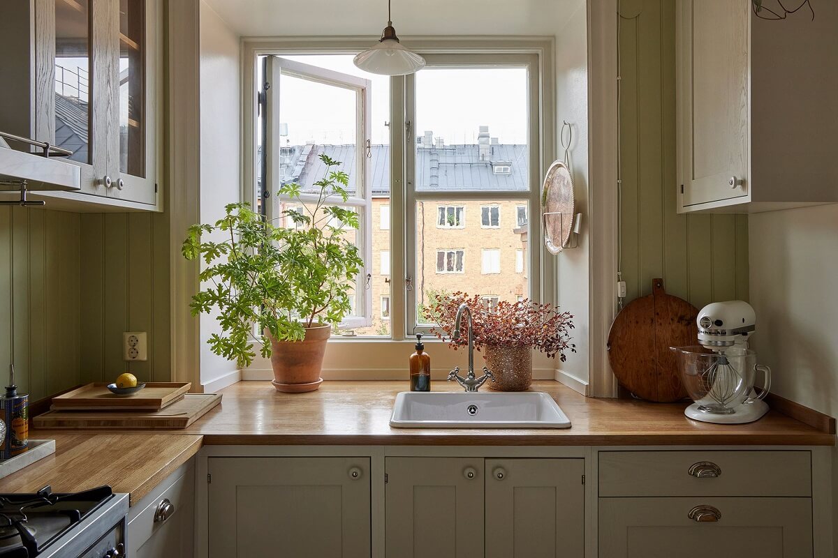 A Small Nordic Home Decorated in Warm Light Colors 6 kitchen-porcelain-sink-window-green-walls-nordroom