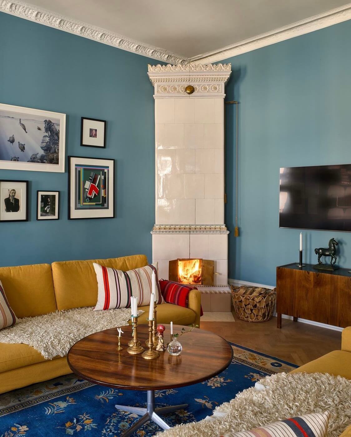 A Swedish Family Home Packed With Color 1 living-room-blue-walls-ochre-yellow-sofa-fireplace-blue-rug-nordroom