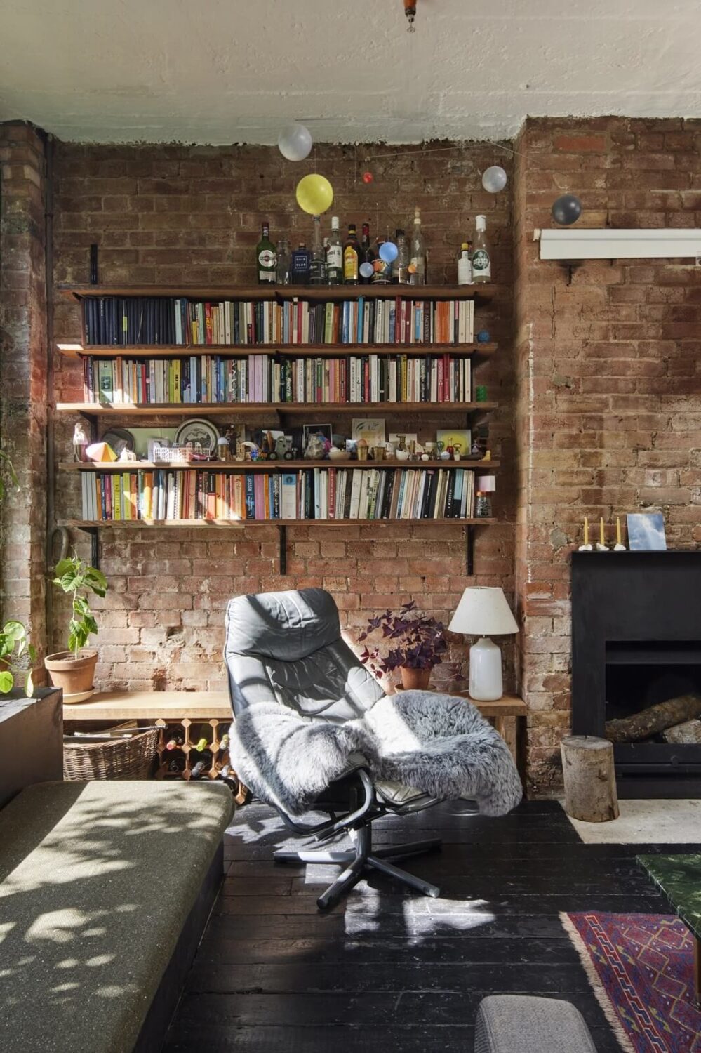 A Unique Home in a Former Furniture Workshop 3 living-room-brick-wall-fireplace-bookshelfs-wooden-floor-nordroom